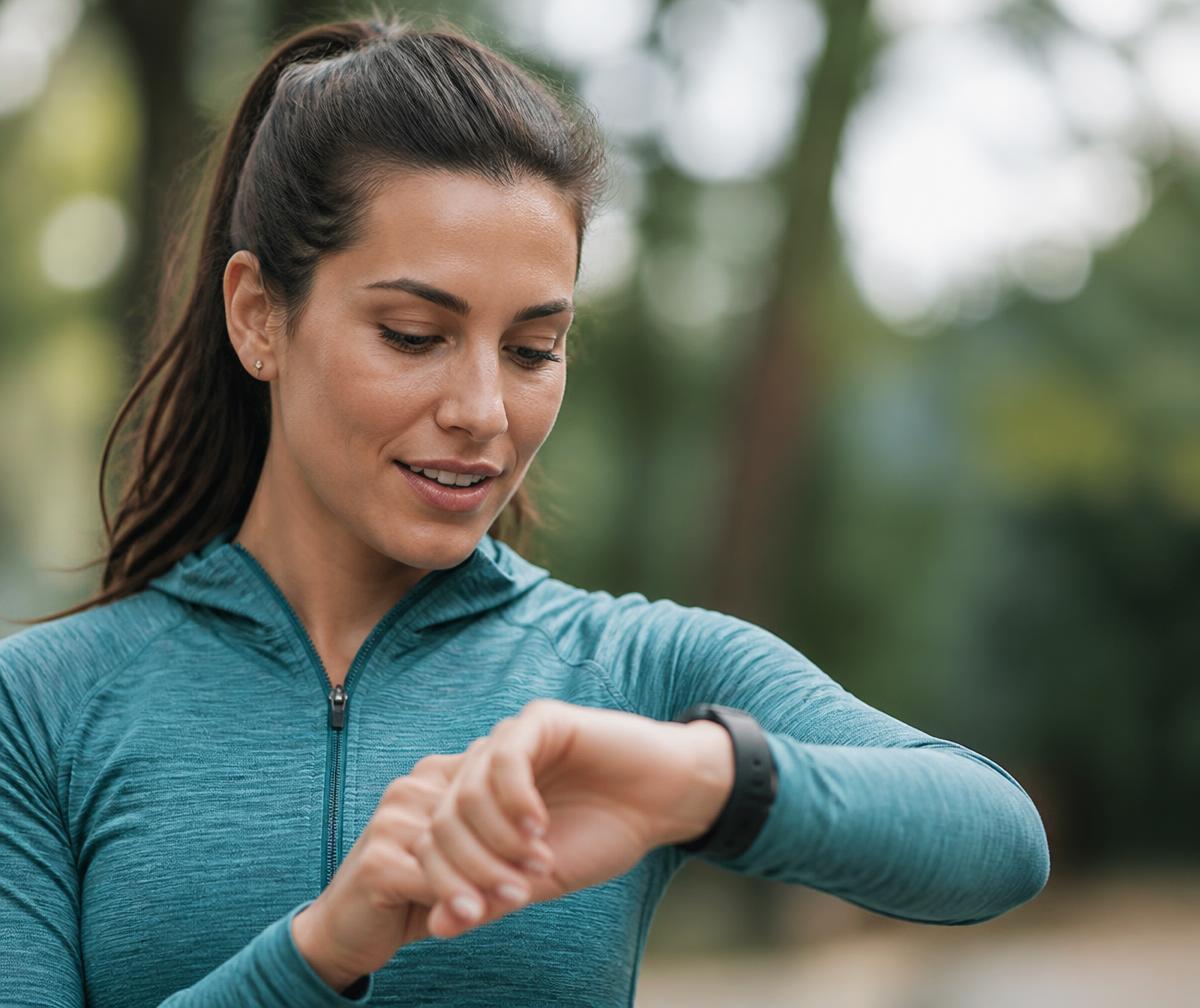 A woman checking her smartwatch after a walk outdoors